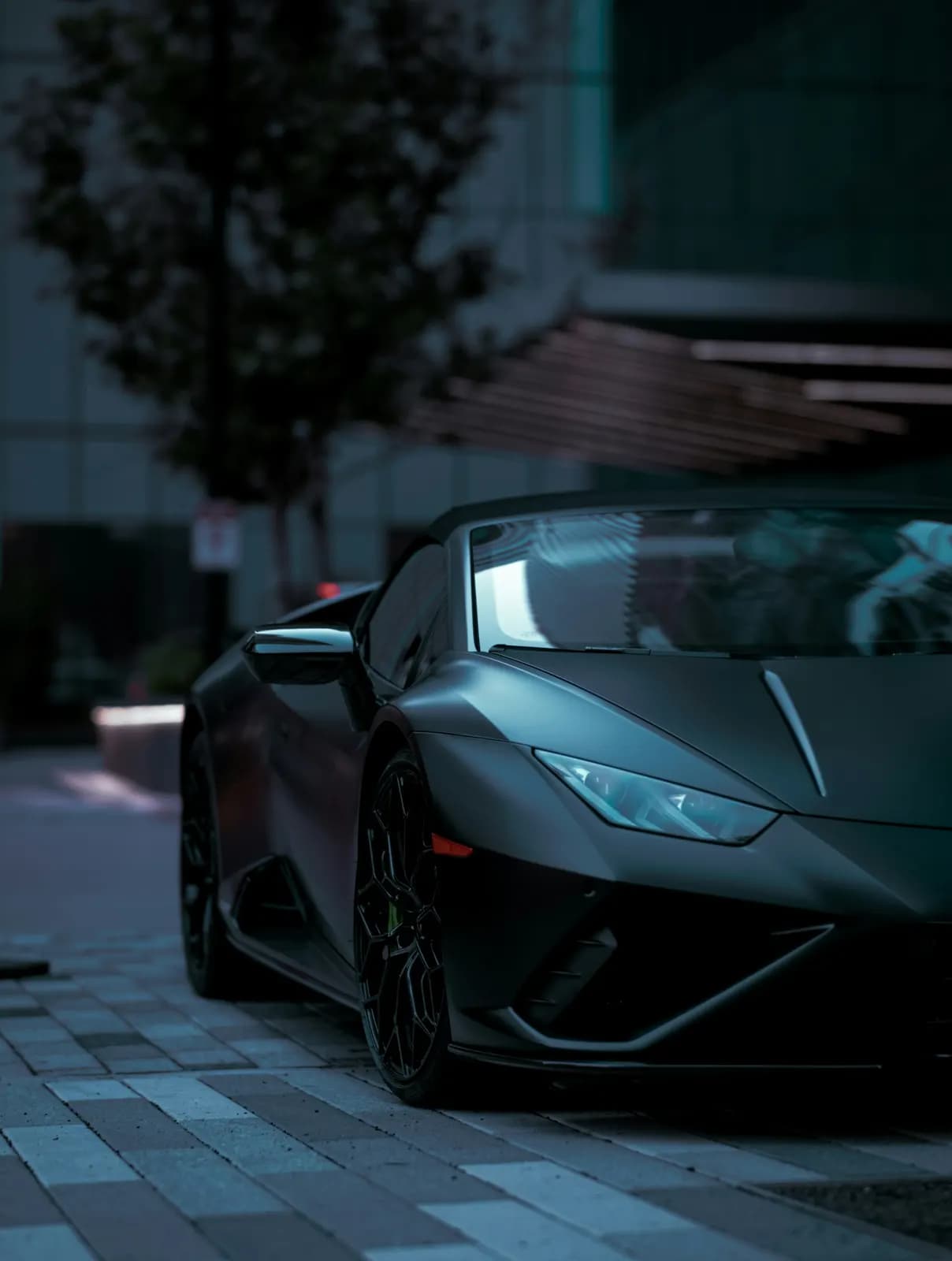 Lamborghini Huracán parked on a city plaza at dusk