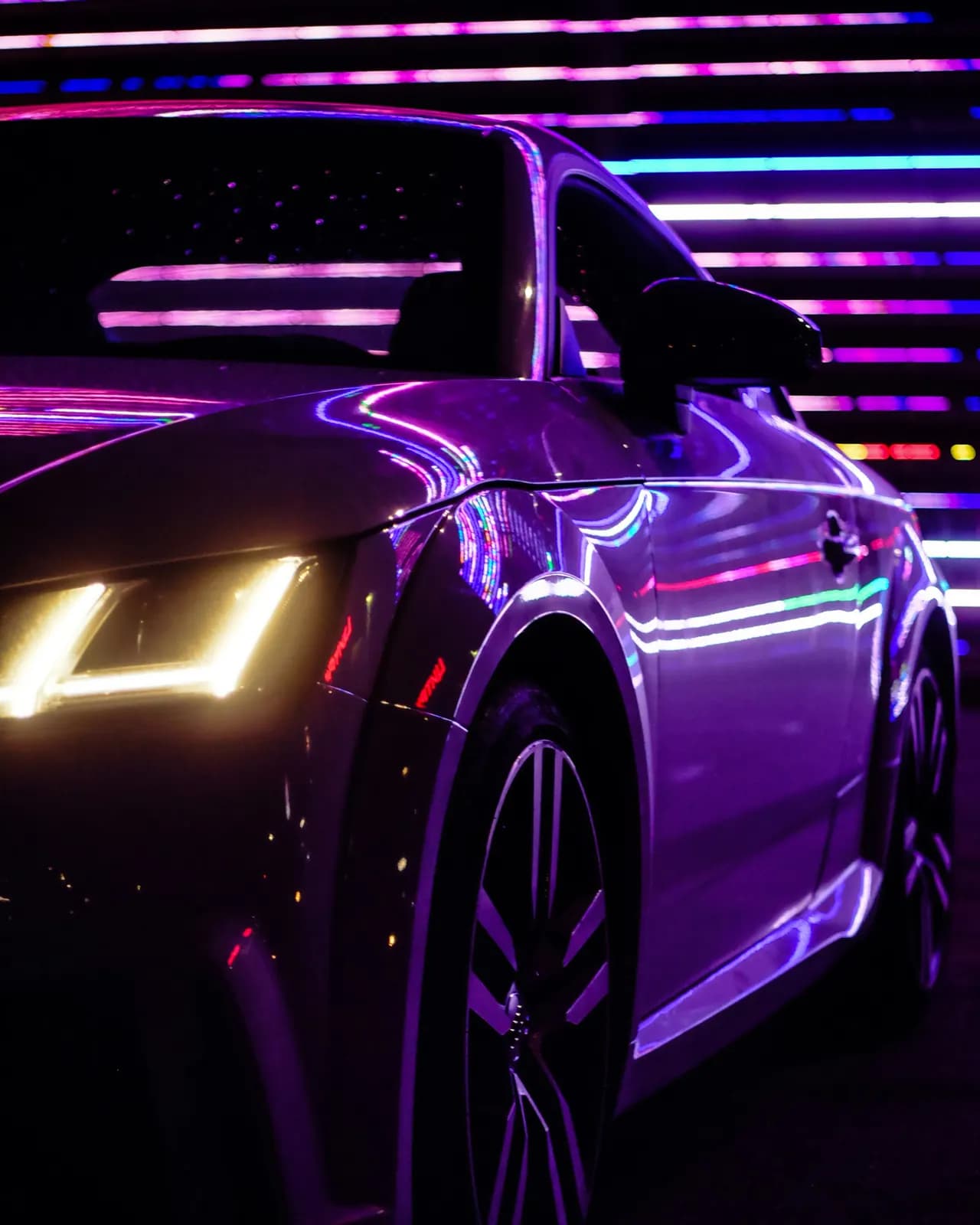 Porsche glowing under purple neon light