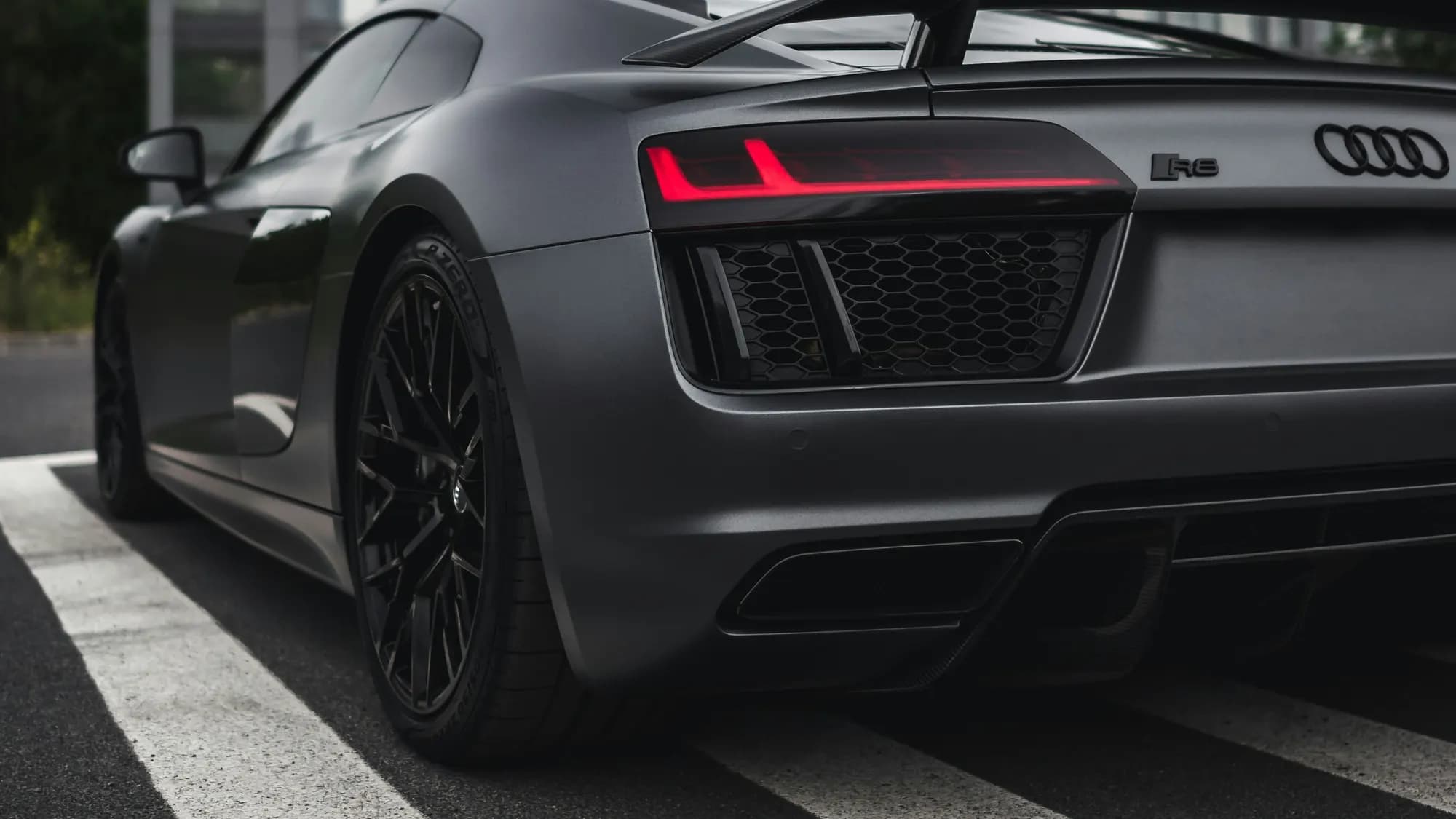 Matte grey Audi R8 with rear wing, rear three-quarter view