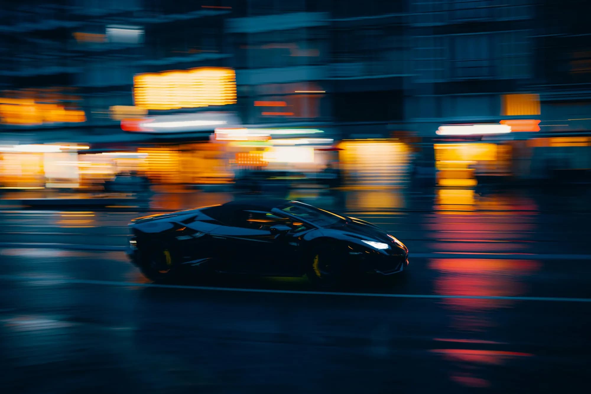 Lamborghini Huracán speeding through a city at night with light trails